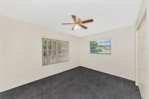 an empty room with a window and a ceiling fan