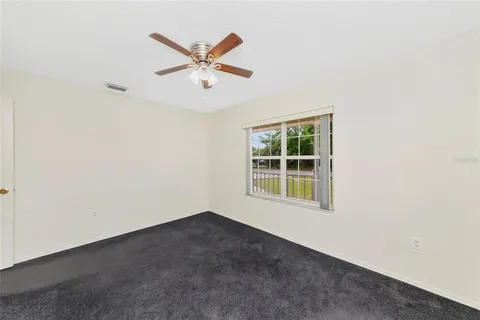 an empty room with a window and a fan