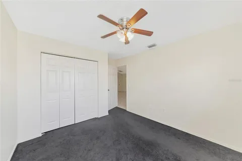 an empty room with closet and ceiling fan