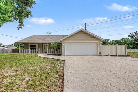 a view of a house with a fence and a big yard