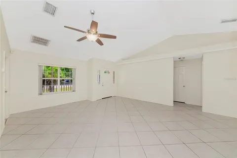 an empty room with windows and fan