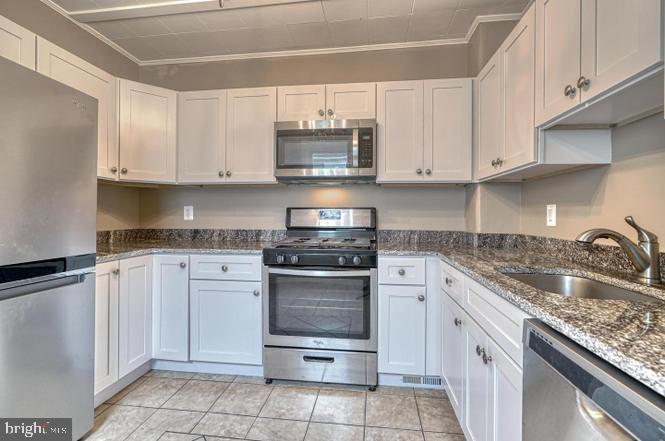 a kitchen with cabinets appliances and a sink