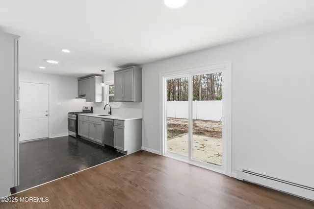 a large white kitchen with a sink stainless steel appliances and cabinets