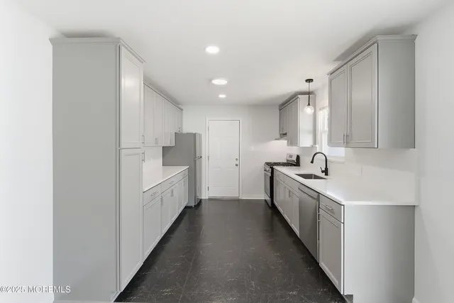 a large white kitchen with a sink a washer and dryer