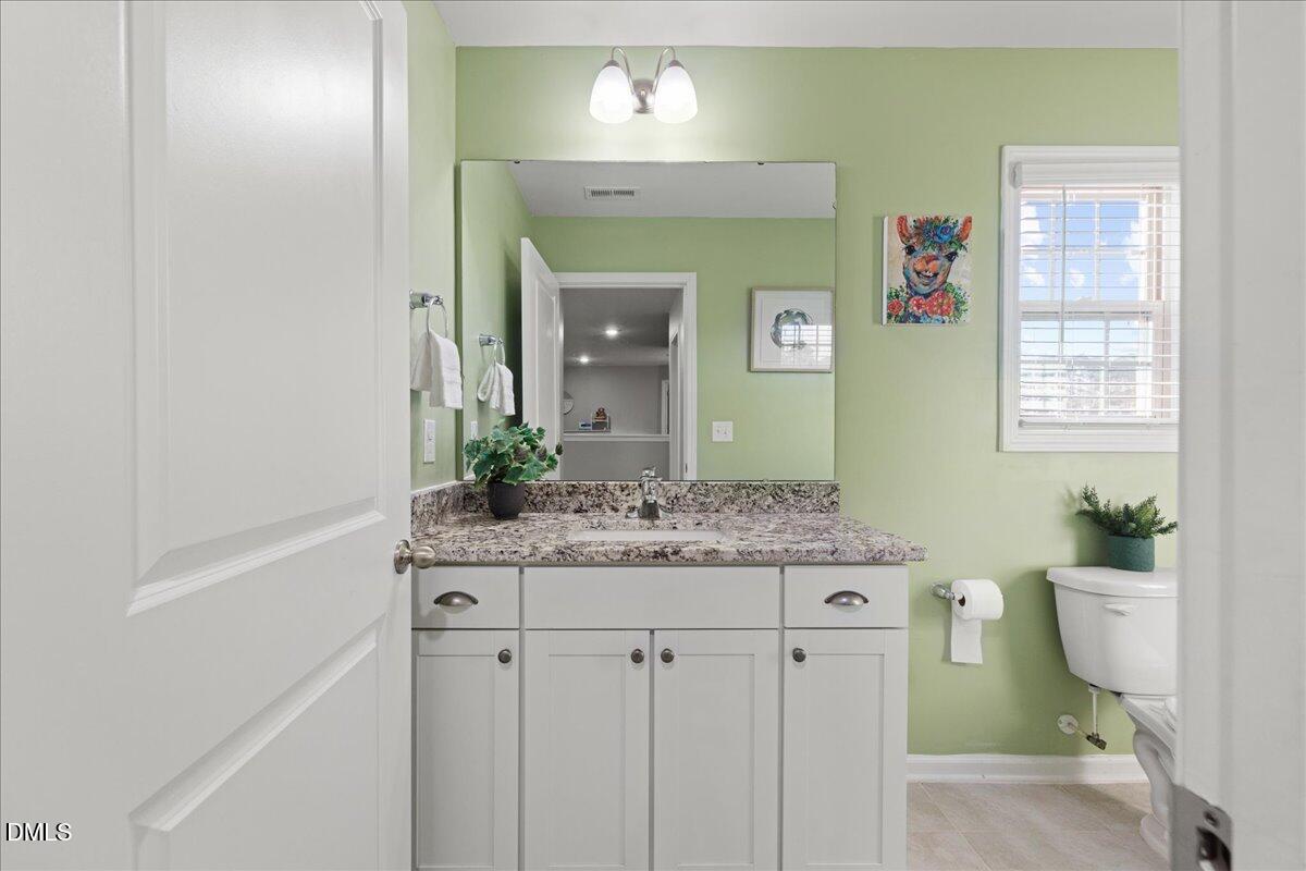 7804 Charters End Street Willow Spring, NC 27592 - Photo 28 of 43 a bathroom with a granite countertop sink and a mirror