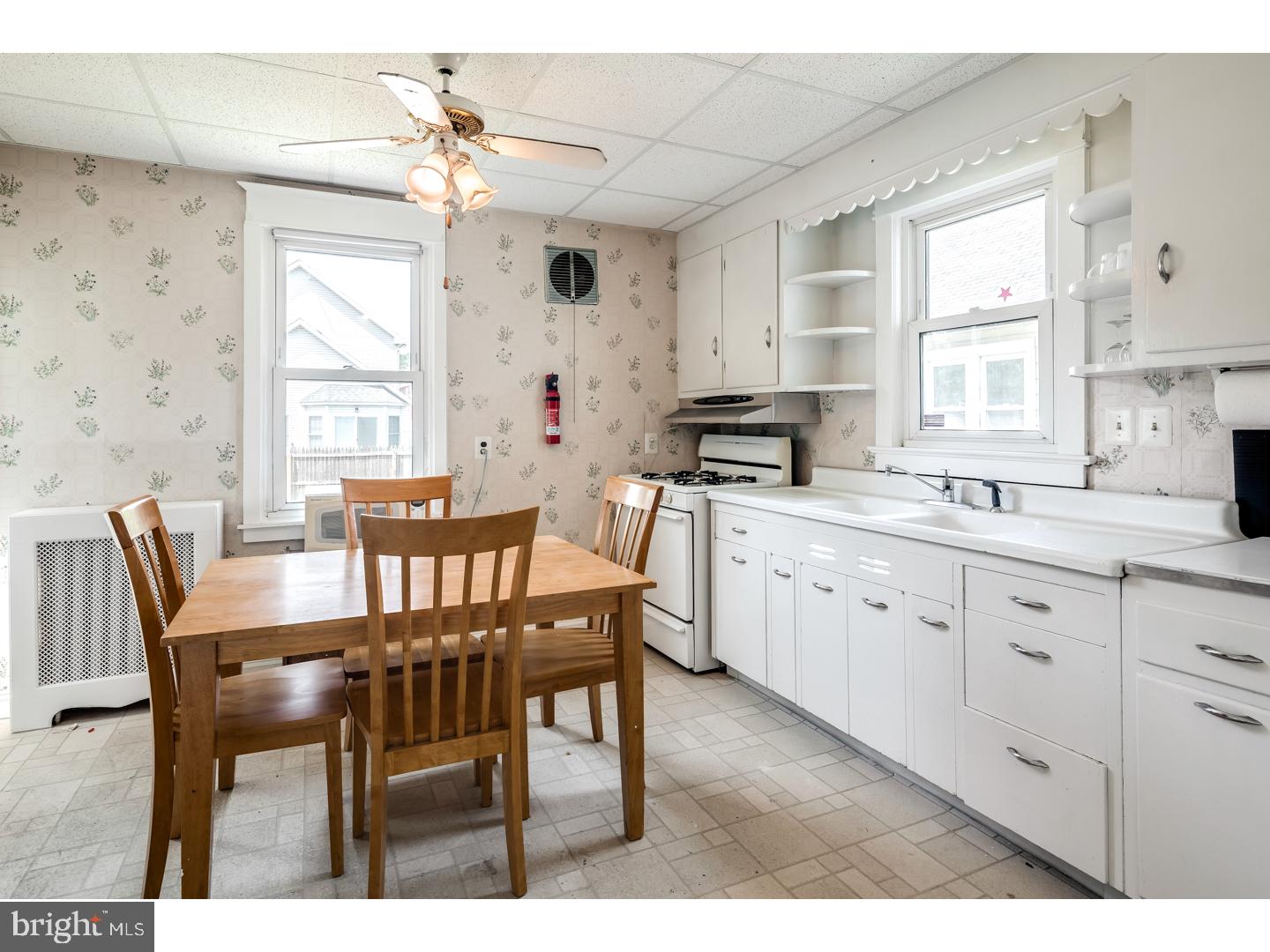 213 Clements Bridge Road Barrington, NJ 08007 - Photo 7 of 25 a kitchen with granite countertop a dining table chairs and white cabinets
