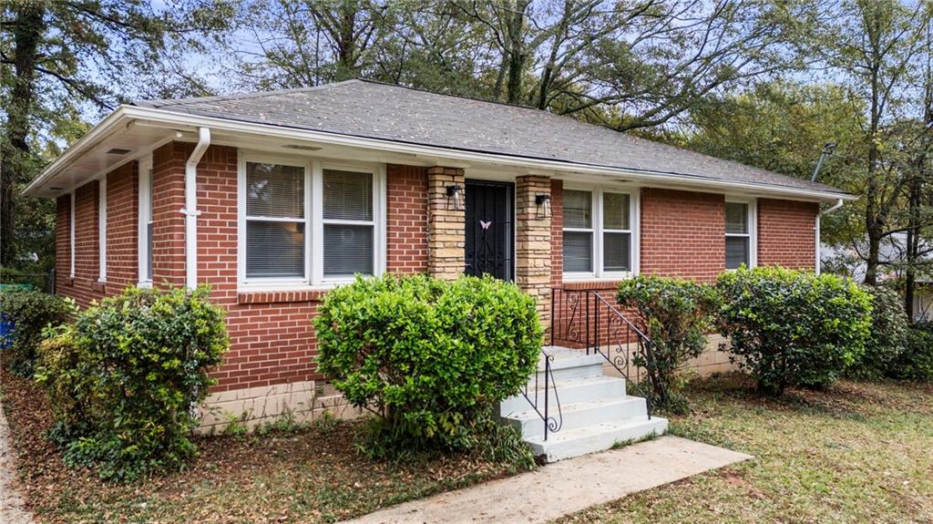 1272 Richard Road Decatur, GA 30032 - Photo 1 of 1 a view of brick house with a large windows plants and large trees