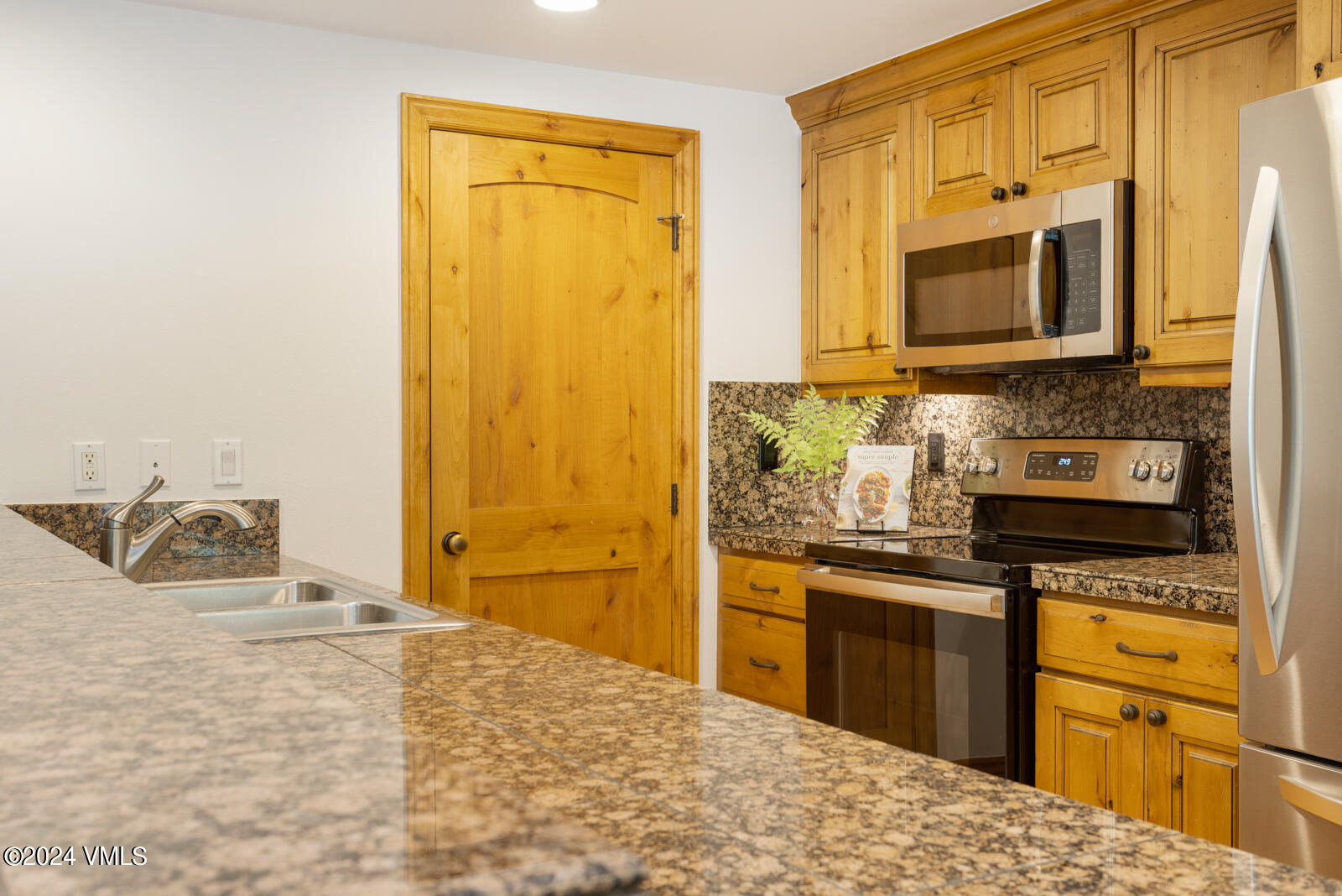 4552 Meadow Drive, Unit 24 Vail, CO 81657 - Photo 9 of 31 a kitchen with stainless steel appliances granite countertop a sink stove and refrigerator
