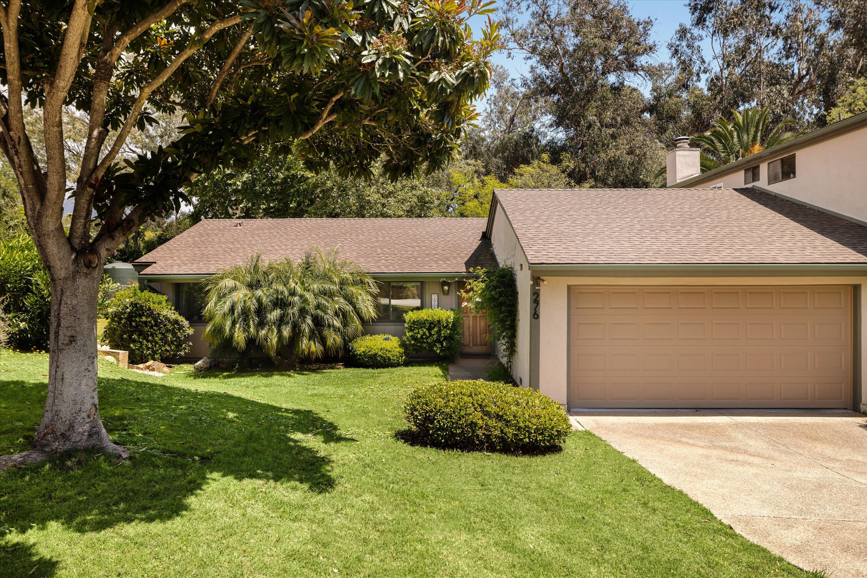 a view of an house with backyard and a tree