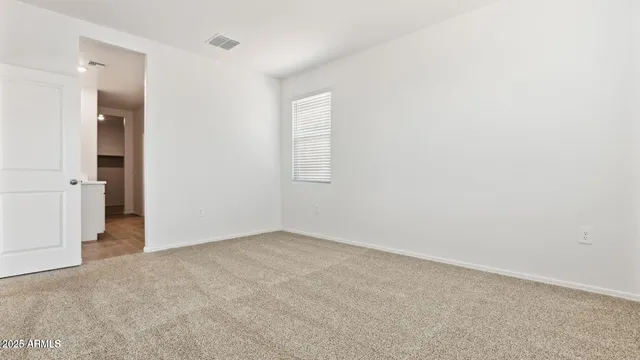 an empty room with closet and windows