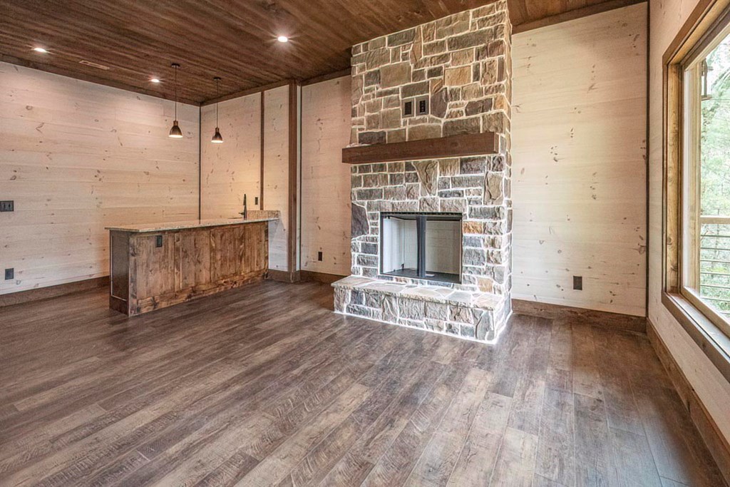 506 Pony Ghost Trail Blue Ridge, GA 30513 - Photo 22 of 62 a view of an empty room with wooden floor fireplace and a window