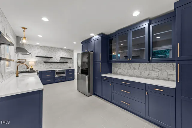 a kitchen with stainless steel appliances granite countertop a refrigerator and a sink