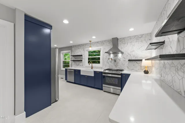 a large kitchen with stainless steel appliances granite countertop a stove a sink and a refrigerator