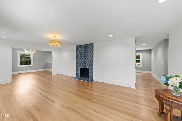 an empty room with wooden floor and potted plant