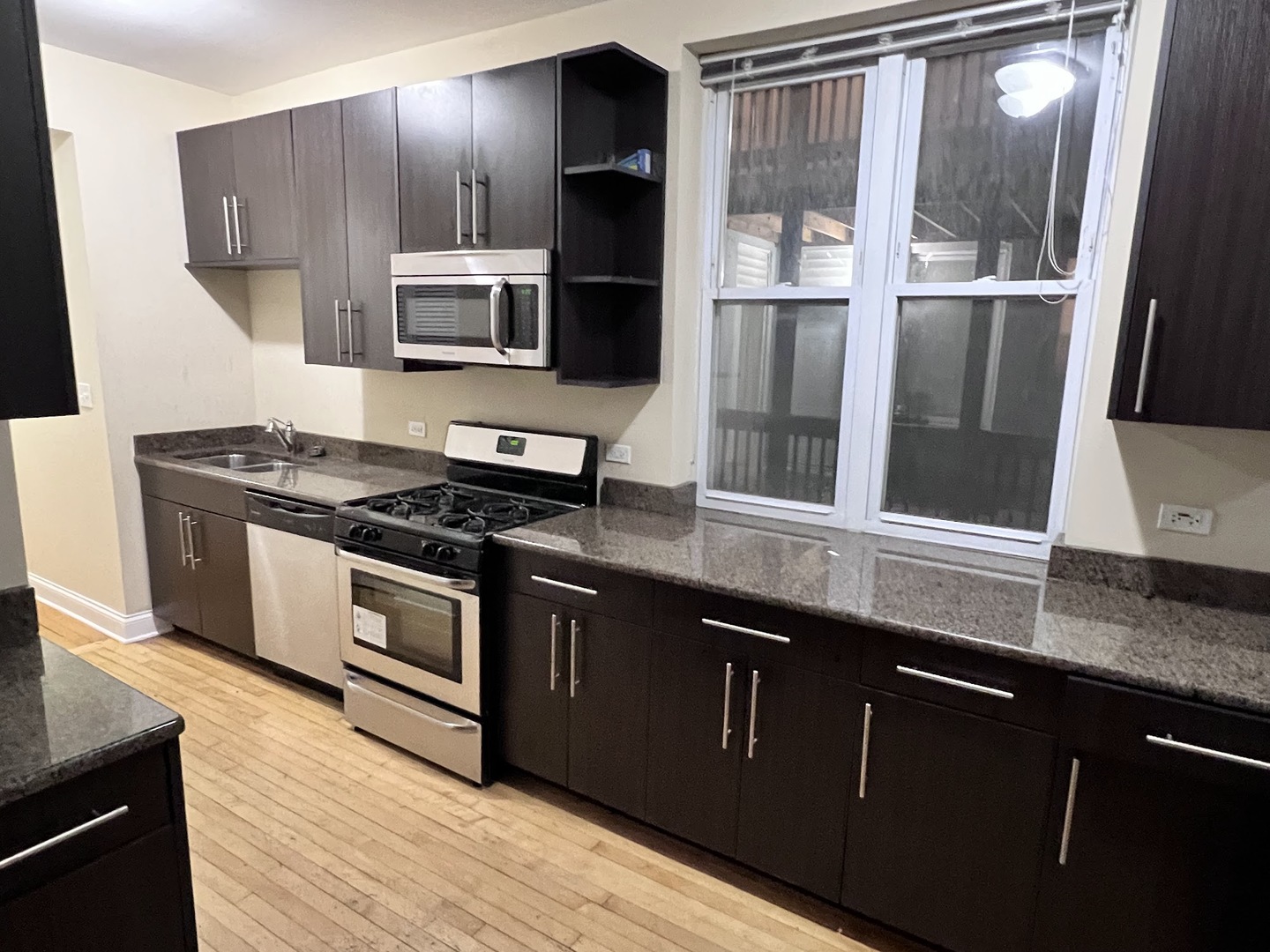 3605 West Leland Avenue, Unit 1E Chicago, IL 60625 - Photo 2 of 14 a kitchen with stainless steel appliances granite countertop a stove and a microwave