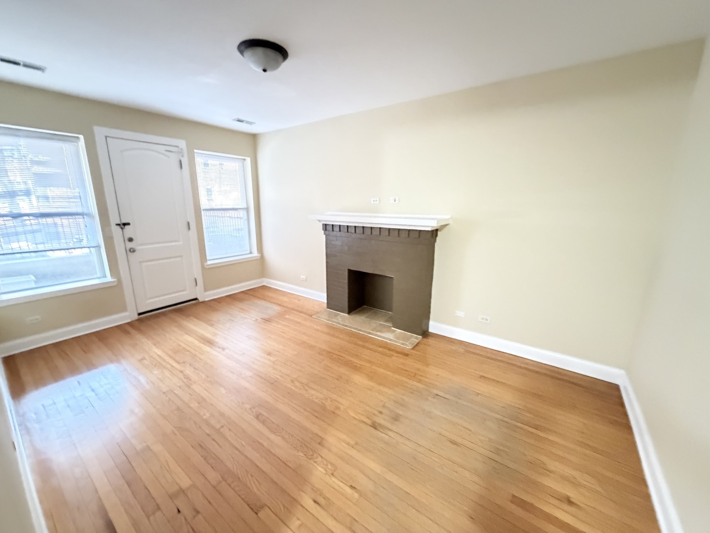 3605 West Leland Avenue, Unit 1E Chicago, IL 60625 - Photo 7 of 14 an empty room with wooden floor and fireplace