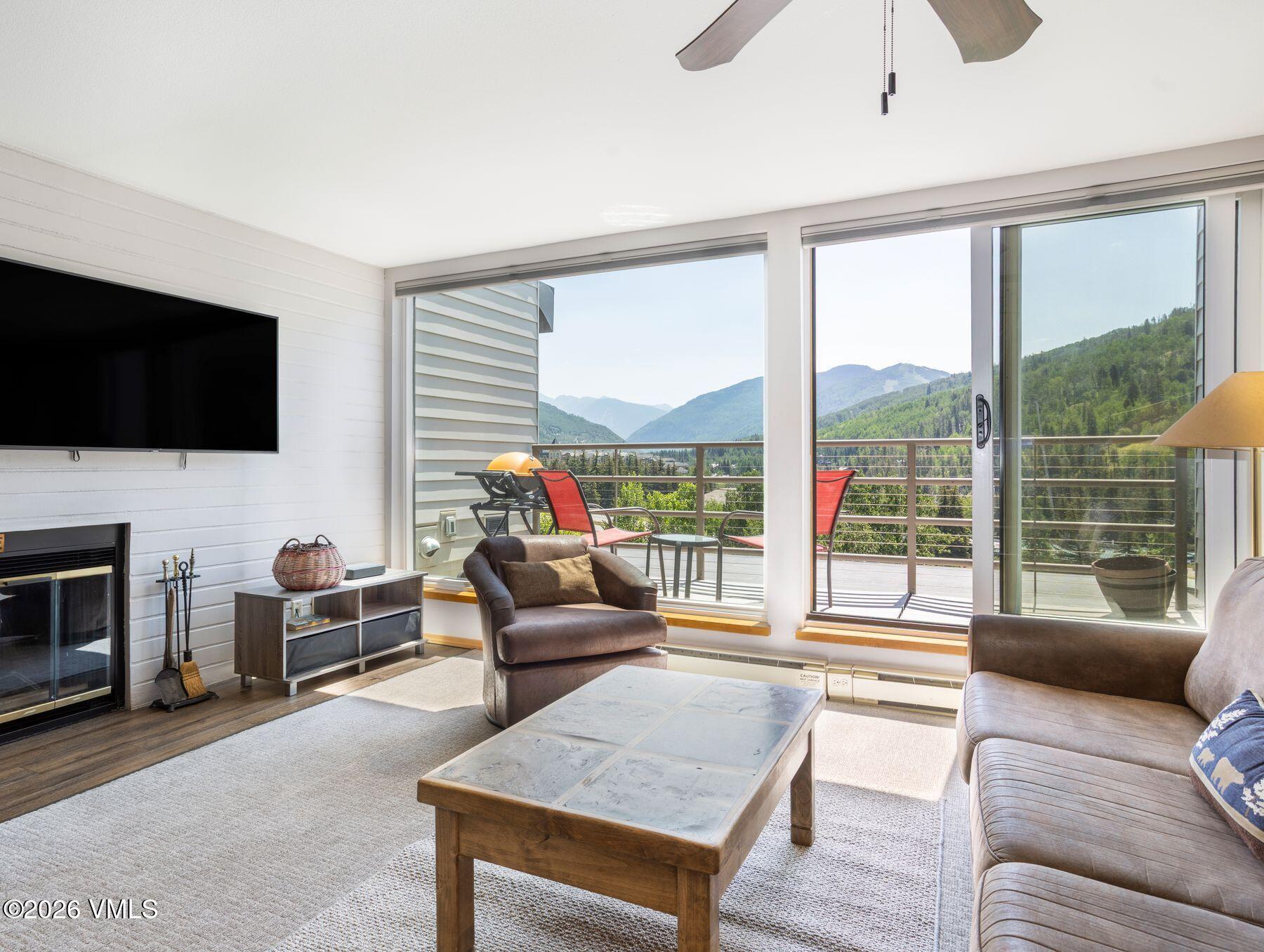 1100 North Frontage Road West, Unit 1503 Vail, CO 81657 - Photo 10 of 32 a living room with furniture a flat screen tv and a large window