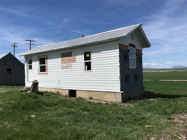 View of home's exterior with a lawn, a metal roof, and an outbuilding