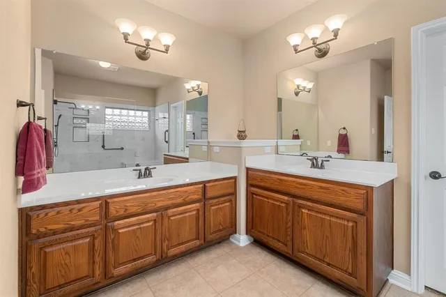 a spacious bathroom with a double vanity sink a large mirror and shower