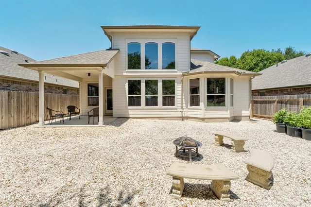 a front view of a house with a yard outdoor seating and covered with trees