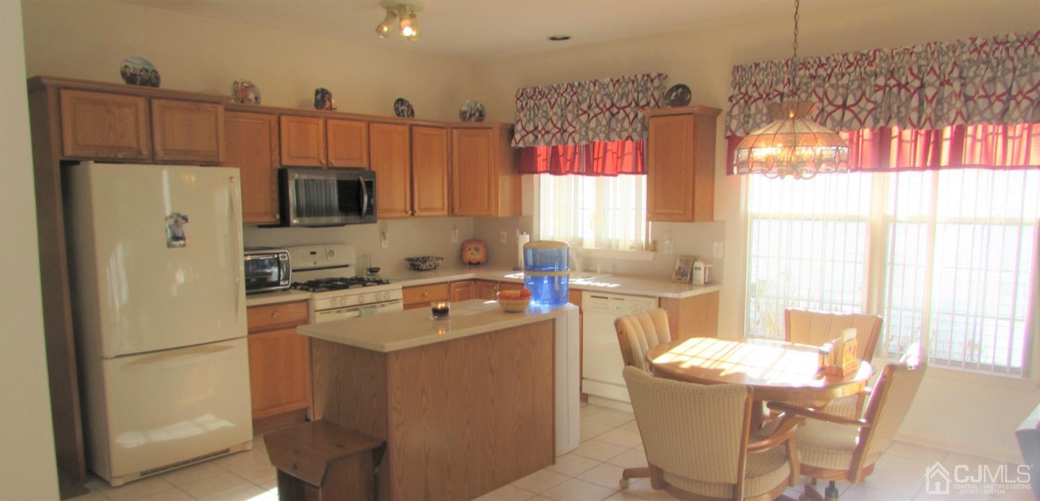 91 Wordsworth Road Brick, NJ 08724 - Photo 17 of 41 a kitchen with a refrigerator a stove a sink dishwasher with a dining table and chairs