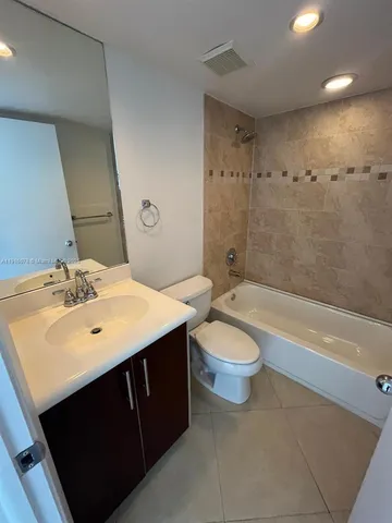 a bathroom with a sink a toilet a mirror and bathtub