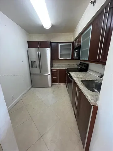 a kitchen with granite countertop a refrigerator and a sink