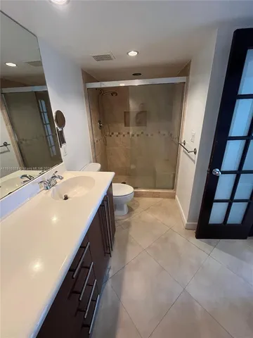 a bathroom with a double vanity sink toilet and shower