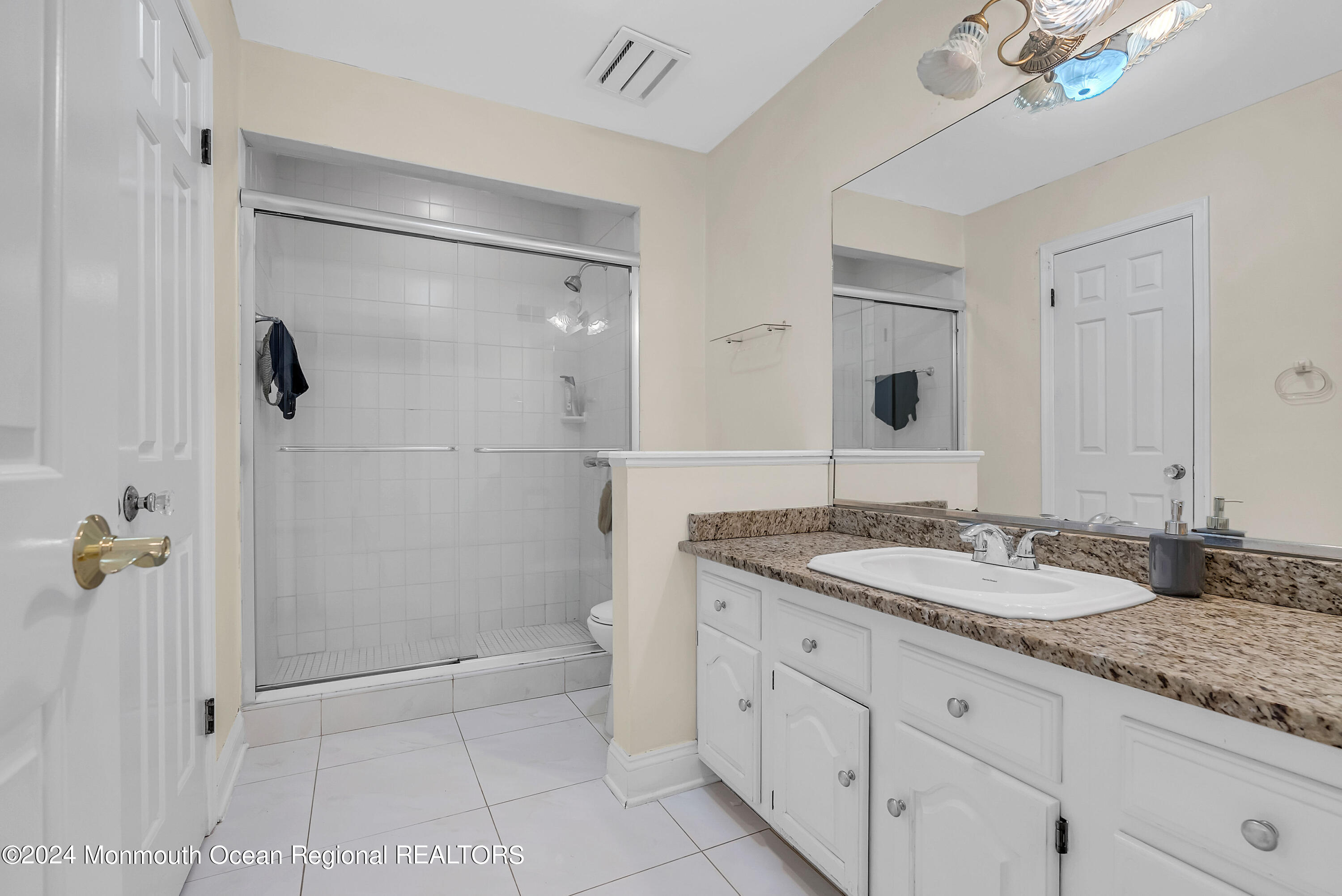 7 Decamp Court West Long Branch, NJ 07764 - Photo 18 of 32 a bathroom with a granite countertop sink a mirror and shower