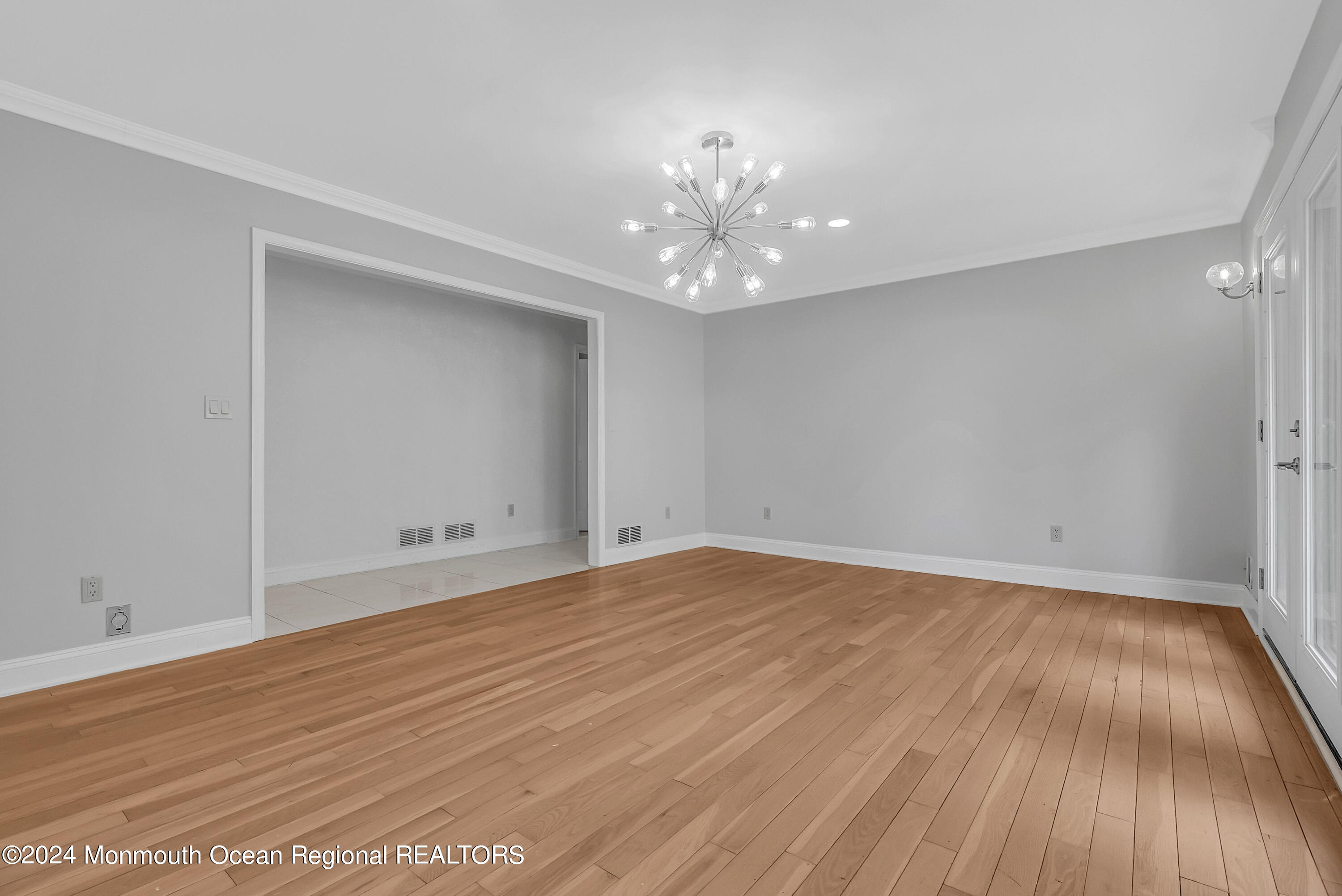 7 Decamp Court West Long Branch, NJ 07764 - Photo 10 of 32 a view of an empty room with wooden floor and chandelier