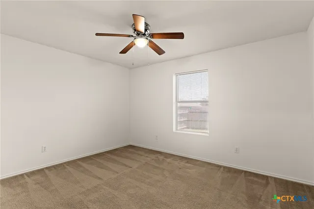 an empty room with a window and a ceiling fan