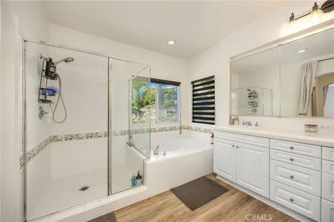 a bathroom with a tub sink shower and mirror