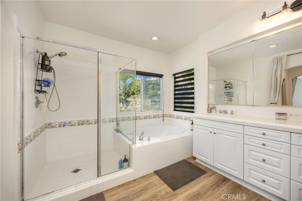 7211 Rock Ridge Terrace West Hills, CA 91307 - Photo 22 of 38 a bathroom with a tub sink shower and mirror