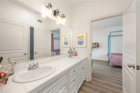 a spacious bathroom with a double vanity sink a mirror and a shower