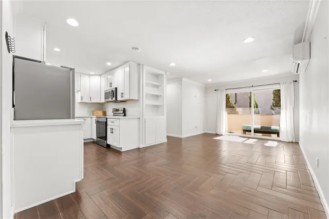 a view of a kitchen with refrigerator and wooden floor