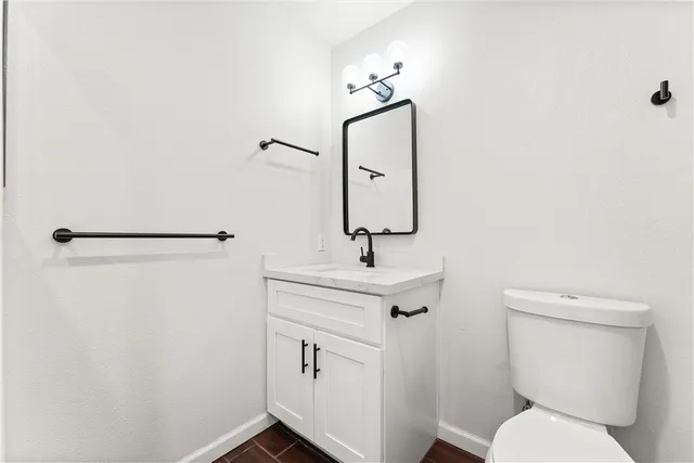 a bathroom with a toilet a sink and mirror