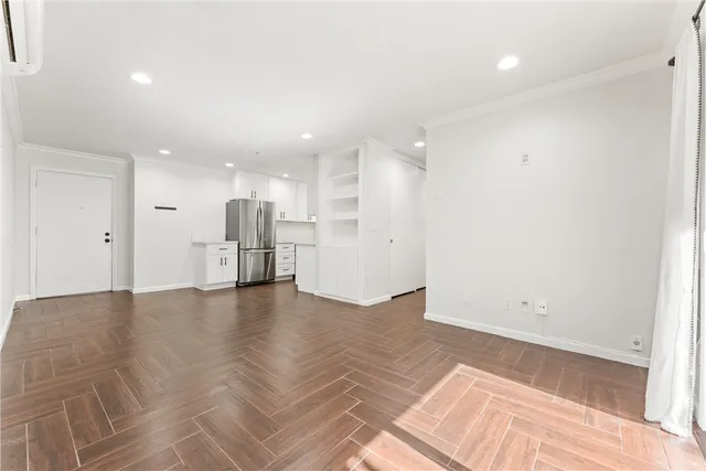 a view of empty room with wooden floor