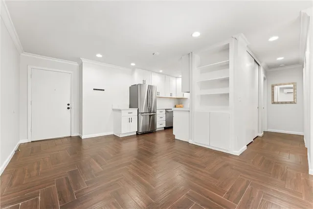 a view of kitchen with refrigerator and white cabinets
