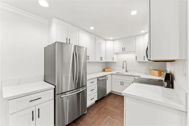 a kitchen with white cabinets and stainless steel appliances