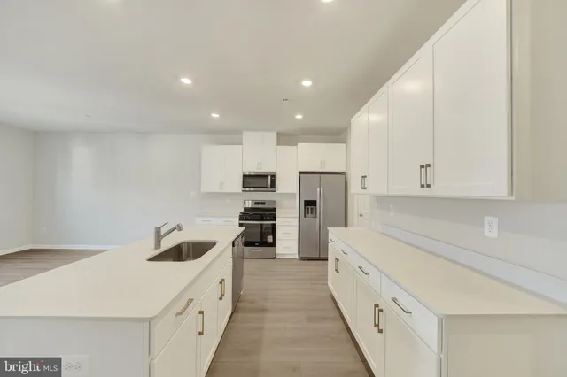 a kitchen with stainless steel appliances a refrigerator sink and cabinets
