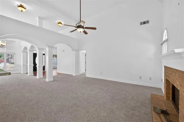 a view of an empty room with a fireplace and a window