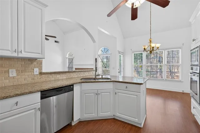 a large kitchen with cabinets a sink and appliances