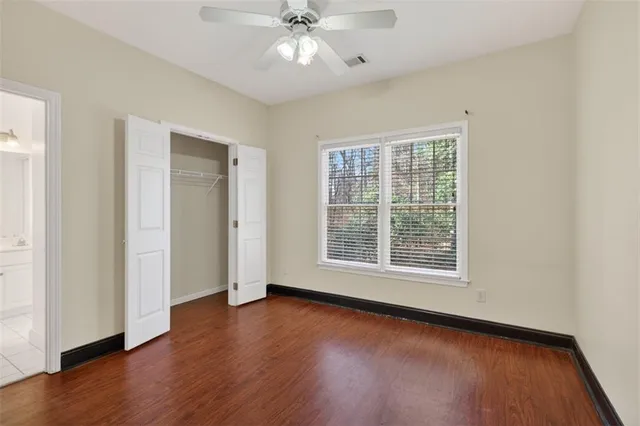 an empty room with wooden floor and closet area