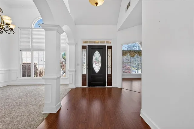 a view of a hallway with wooden floor and a window