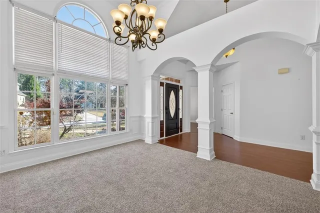 an empty room with windows and fireplace