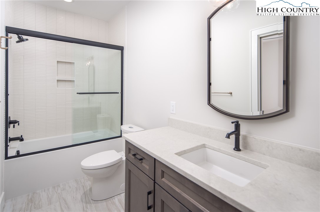 353 Calico Court Boone, NC 28607 - Photo 21 of 50 a bathroom with a sink a toilet and a mirror