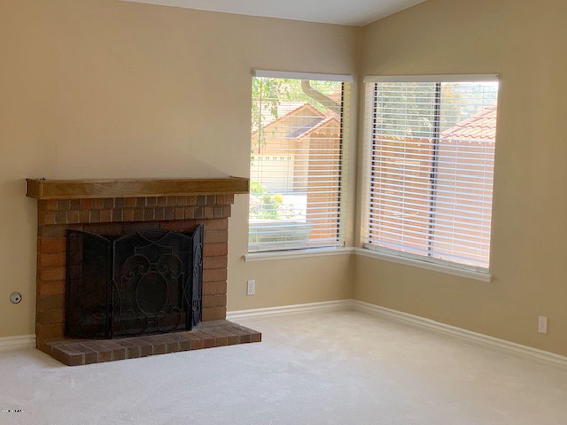 13653 Bear Valley Road Moorpark, CA 93021 - Photo 4 of 18 an empty room with a fireplace and windows