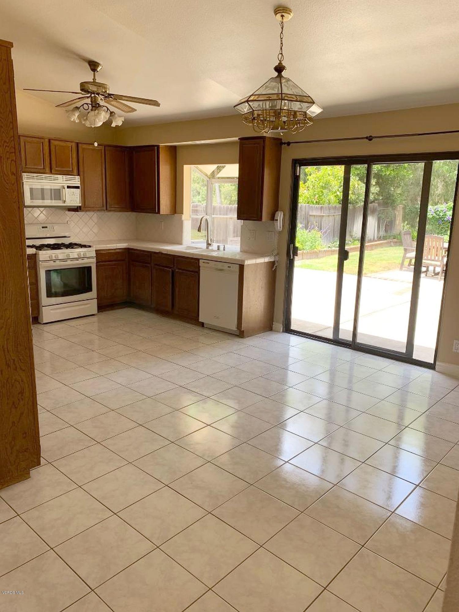 13653 Bear Valley Road Moorpark, CA 93021 - Photo 6 of 18 a large kitchen with granite countertop a sink and a stove top oven with wooden floor
