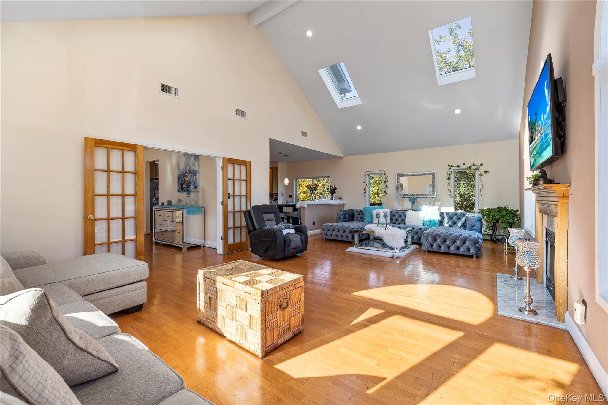 35 Pierce Road Stony Point, NY 10980 - Photo 11 of 45 Living area featuring french doors, beam ceiling, a glass covered fireplace, high vaulted ceiling, and light wood-type flooring