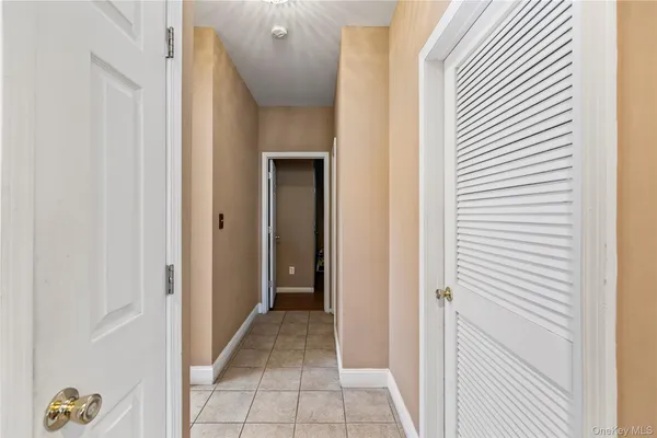 a view of a hallway with wooden floor and closet